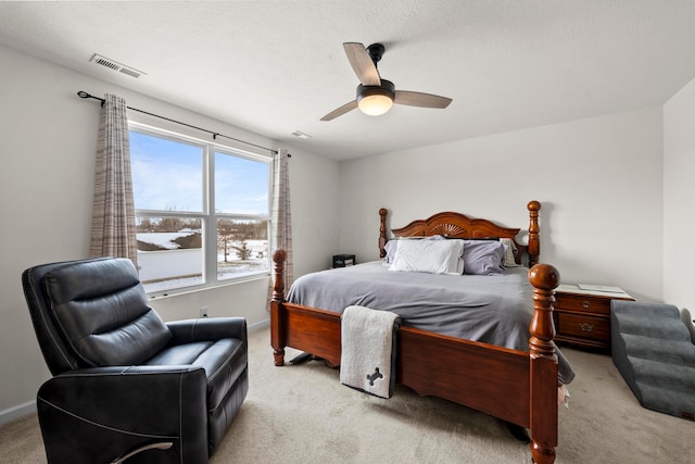 bedroom with light carpet, a ceiling fan, visible vents, and baseboards