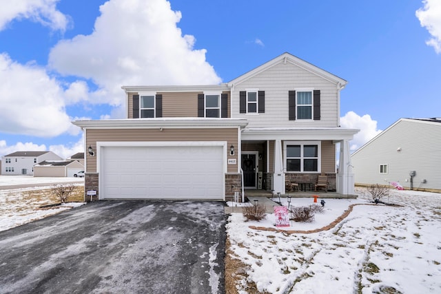 view of front of property with a garage, covered porch, aphalt driveway, and stone siding