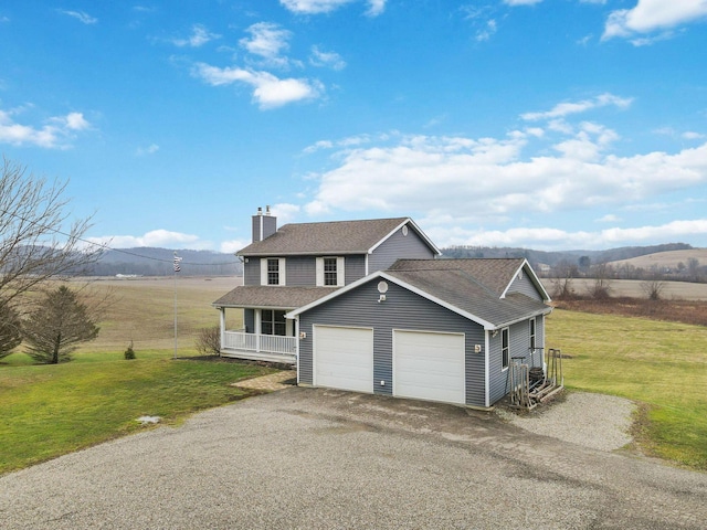 view of front of property featuring a garage, a mountain view, covered porch, and a front yard