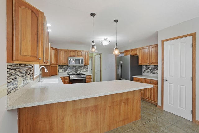 kitchen featuring appliances with stainless steel finishes, decorative light fixtures, sink, tile patterned flooring, and kitchen peninsula