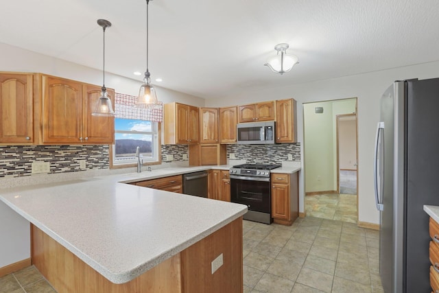 kitchen featuring sink, appliances with stainless steel finishes, hanging light fixtures, tasteful backsplash, and kitchen peninsula