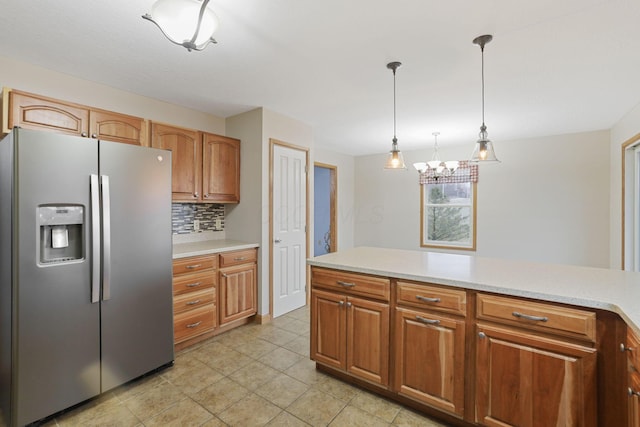 kitchen featuring hanging light fixtures, stainless steel refrigerator with ice dispenser, tasteful backsplash, and light tile patterned flooring