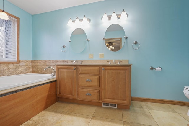 bathroom featuring tile patterned floors, toilet, a bathtub, and vanity