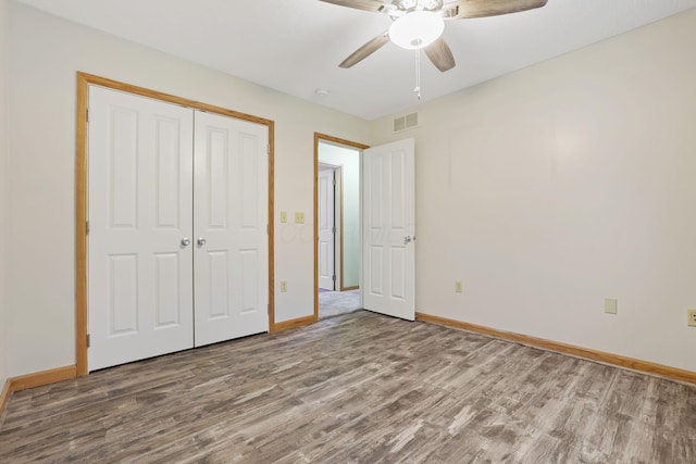 unfurnished bedroom with hardwood / wood-style floors, a closet, and ceiling fan