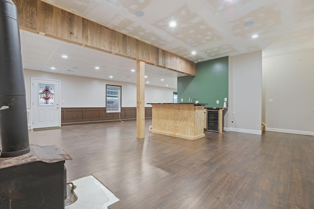 interior space with a kitchen bar, dark hardwood / wood-style floors, a center island, and a wood stove