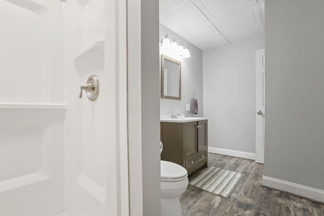 bathroom featuring hardwood / wood-style flooring, vanity, walk in shower, and toilet