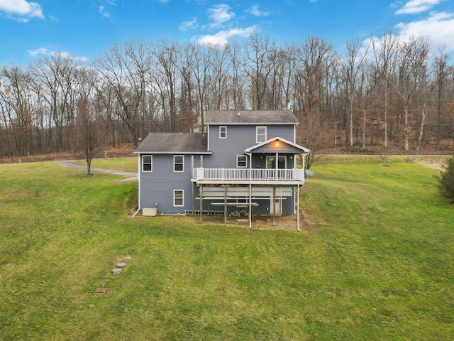 rear view of property with a wooden deck and a lawn