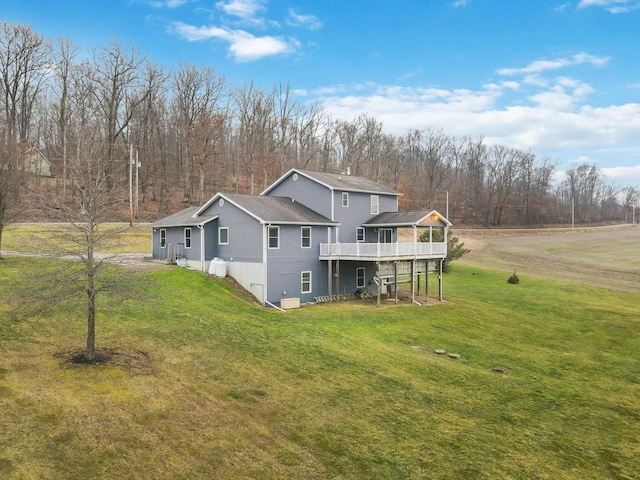 back of property with a wooden deck and a yard