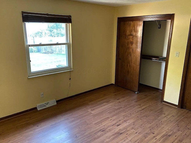 unfurnished bedroom with light hardwood / wood-style floors and a closet