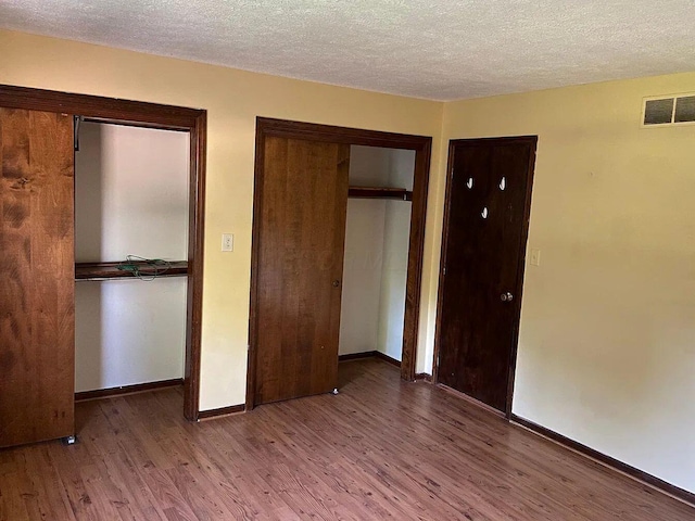 unfurnished bedroom with hardwood / wood-style floors and a textured ceiling