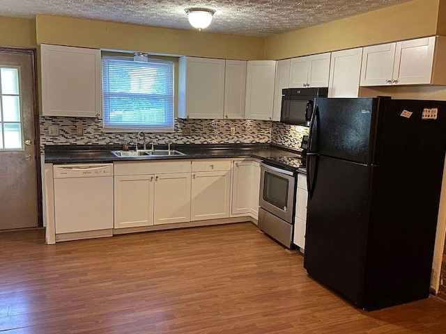 kitchen featuring sink, black appliances, white cabinets, decorative backsplash, and light wood-type flooring