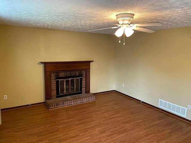 unfurnished living room with hardwood / wood-style floors, a textured ceiling, a fireplace, and ceiling fan