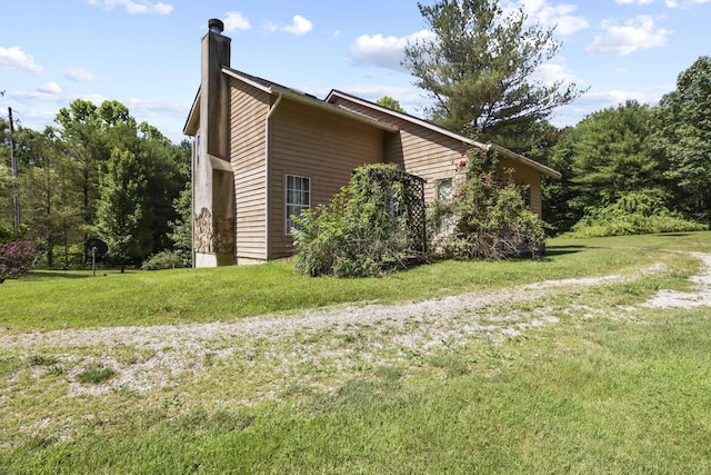 view of home's exterior with a lawn and a chimney