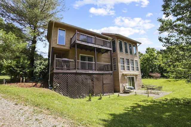 rear view of property featuring a patio, a balcony, and a lawn