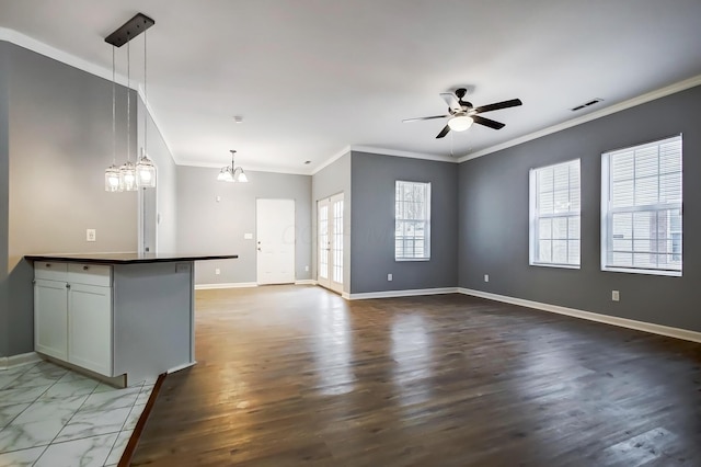 kitchen with visible vents, pendant lighting, dark countertops, crown molding, and baseboards