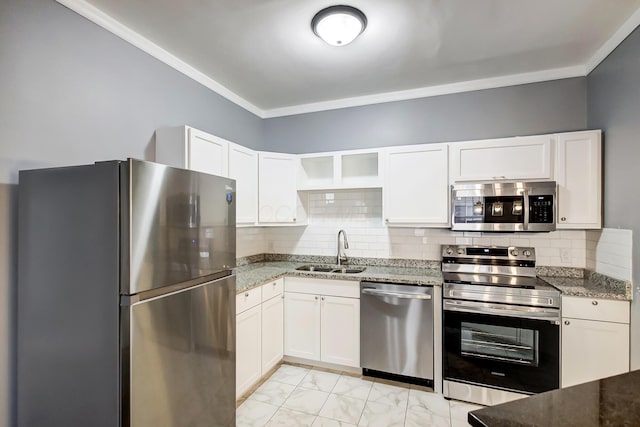 kitchen with marble finish floor, a sink, light stone counters, backsplash, and appliances with stainless steel finishes