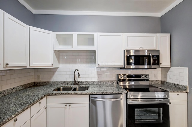 kitchen with white cabinets, tasteful backsplash, appliances with stainless steel finishes, and a sink