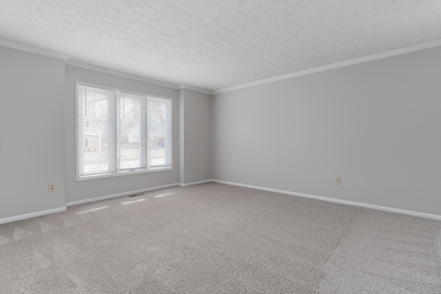 empty room with a textured ceiling, baseboards, crown molding, and light colored carpet