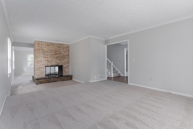 unfurnished living room featuring carpet, stairs, crown molding, and a textured ceiling