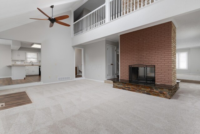 unfurnished living room with baseboards, a fireplace, visible vents, and carpet flooring