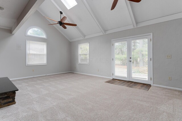 unfurnished living room with carpet floors, french doors, beamed ceiling, and high vaulted ceiling