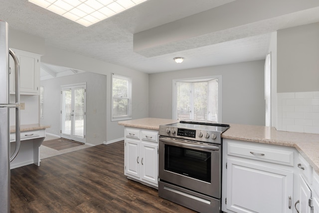 kitchen with appliances with stainless steel finishes, light countertops, white cabinets, and dark wood-type flooring