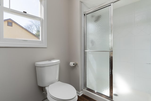 full bath featuring a shower stall and toilet