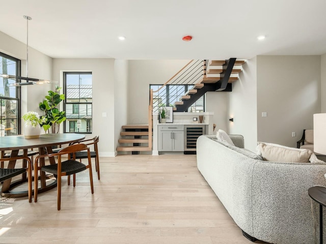 living room with beverage cooler and light hardwood / wood-style flooring