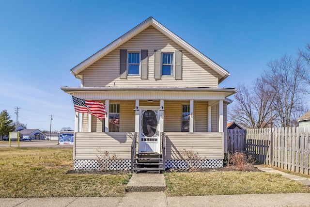 view of front of home with entry steps, a front lawn, fence, and covered porch