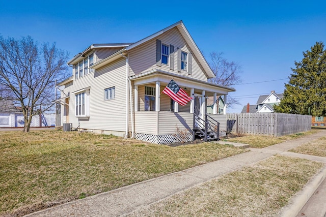 view of front of house with a front lawn, central AC unit, and fence