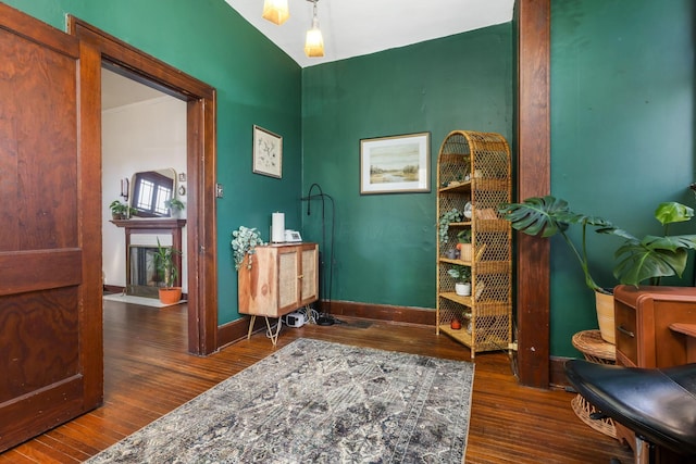 interior space with a fireplace, wood finished floors, and baseboards