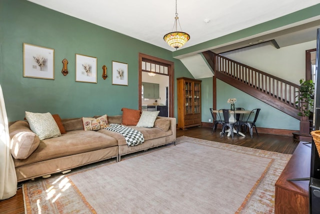 living area with stairs, baseboards, and wood finished floors