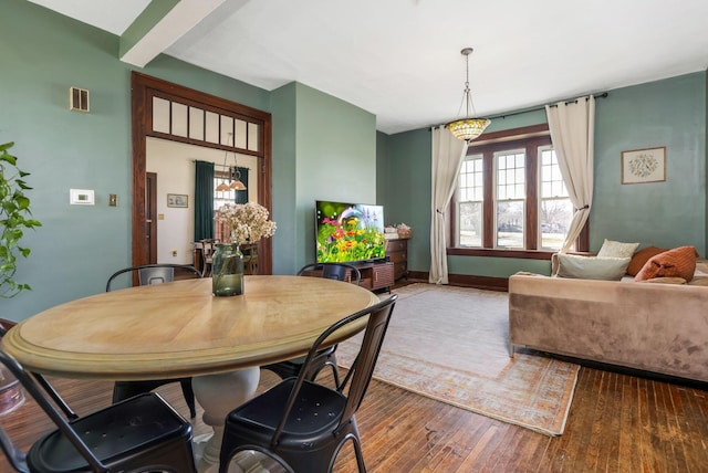 dining area with visible vents, baseboards, and hardwood / wood-style flooring