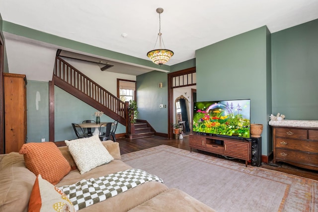 living room with stairs, baseboards, and wood finished floors