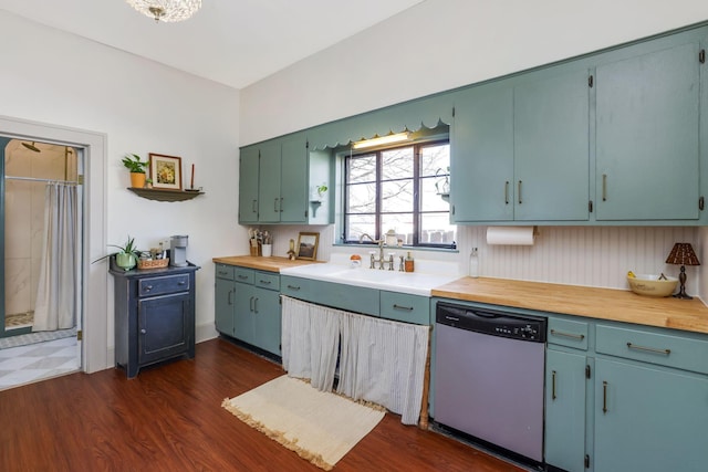 kitchen with dishwasher, light countertops, dark wood-style floors, and a sink