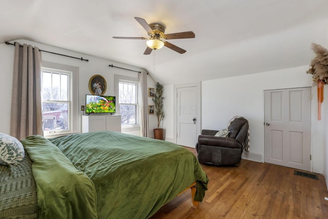 bedroom with visible vents, a ceiling fan, vaulted ceiling, and hardwood / wood-style flooring