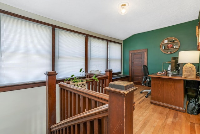 office space featuring lofted ceiling, a textured ceiling, and light wood finished floors