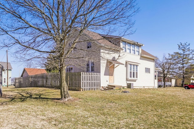 exterior space with a yard, fence, and cooling unit