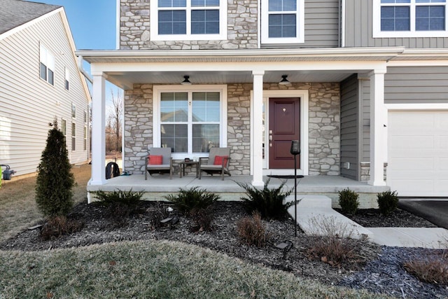 view of exterior entry with covered porch and a garage