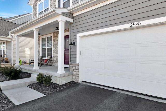 entrance to property with covered porch and a garage