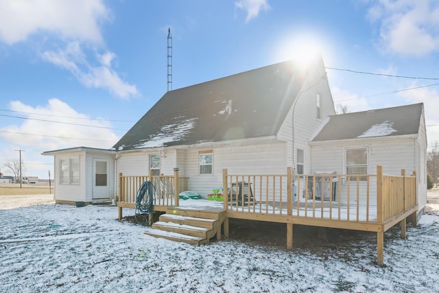 snow covered rear of property featuring a wooden deck