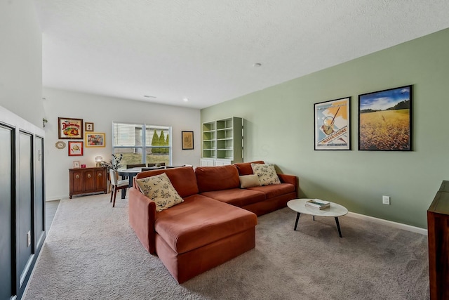 living room featuring light carpet, a textured ceiling, and baseboards