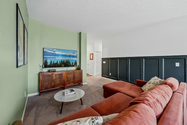 carpeted living room featuring a decorative wall and a textured ceiling