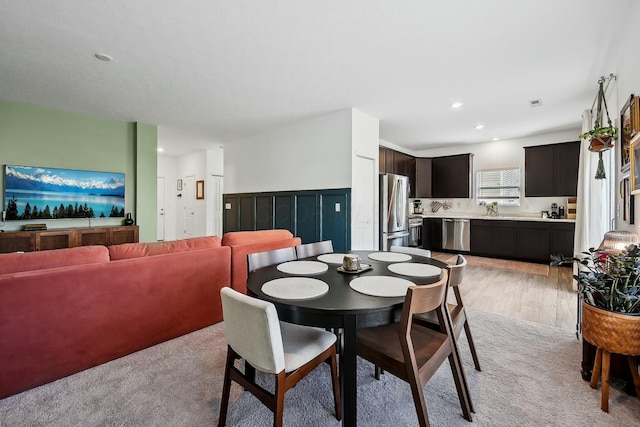 dining area with light wood-style flooring, light colored carpet, and recessed lighting