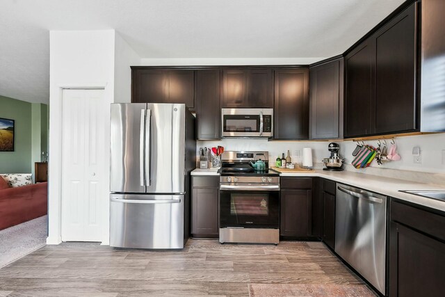 kitchen with appliances with stainless steel finishes, light countertops, and dark brown cabinets