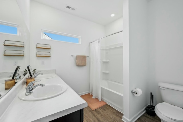 bathroom featuring toilet, wood finished floors, a sink, and visible vents