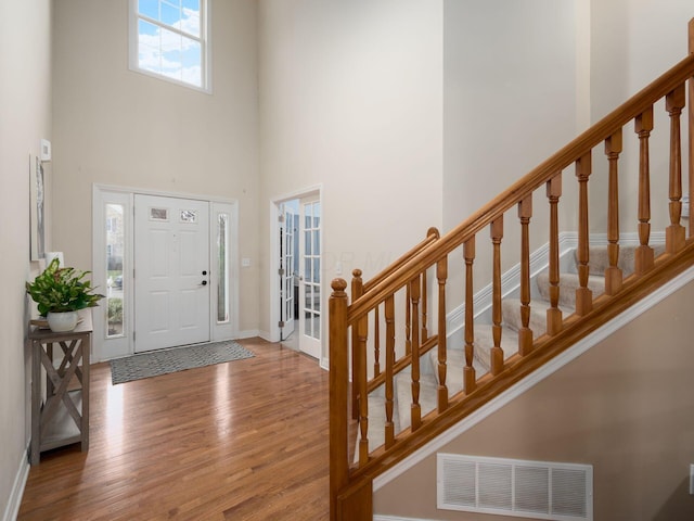 foyer entrance with hardwood / wood-style floors and a high ceiling