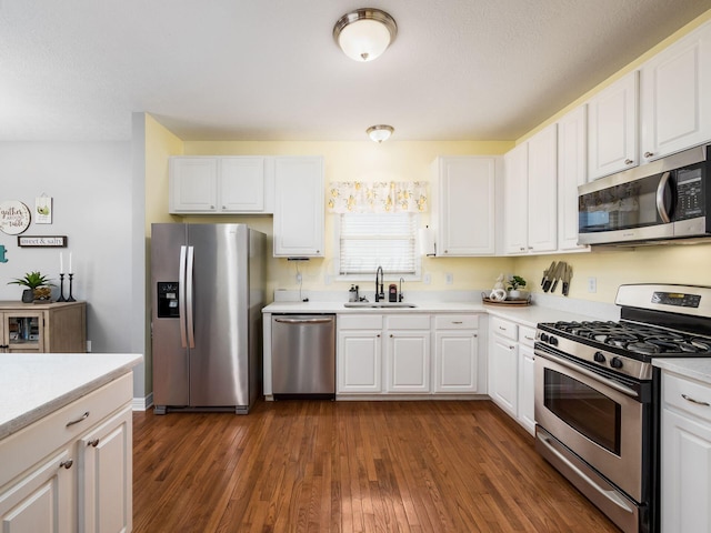 kitchen featuring stainless steel appliances, sink, white cabinets, and dark hardwood / wood-style flooring