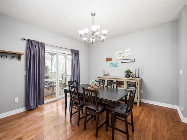 dining space with wood-type flooring and a chandelier