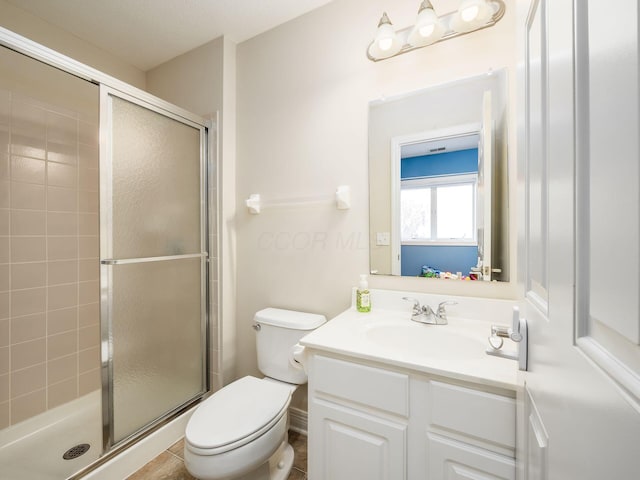 bathroom featuring vanity, toilet, and a shower with shower door